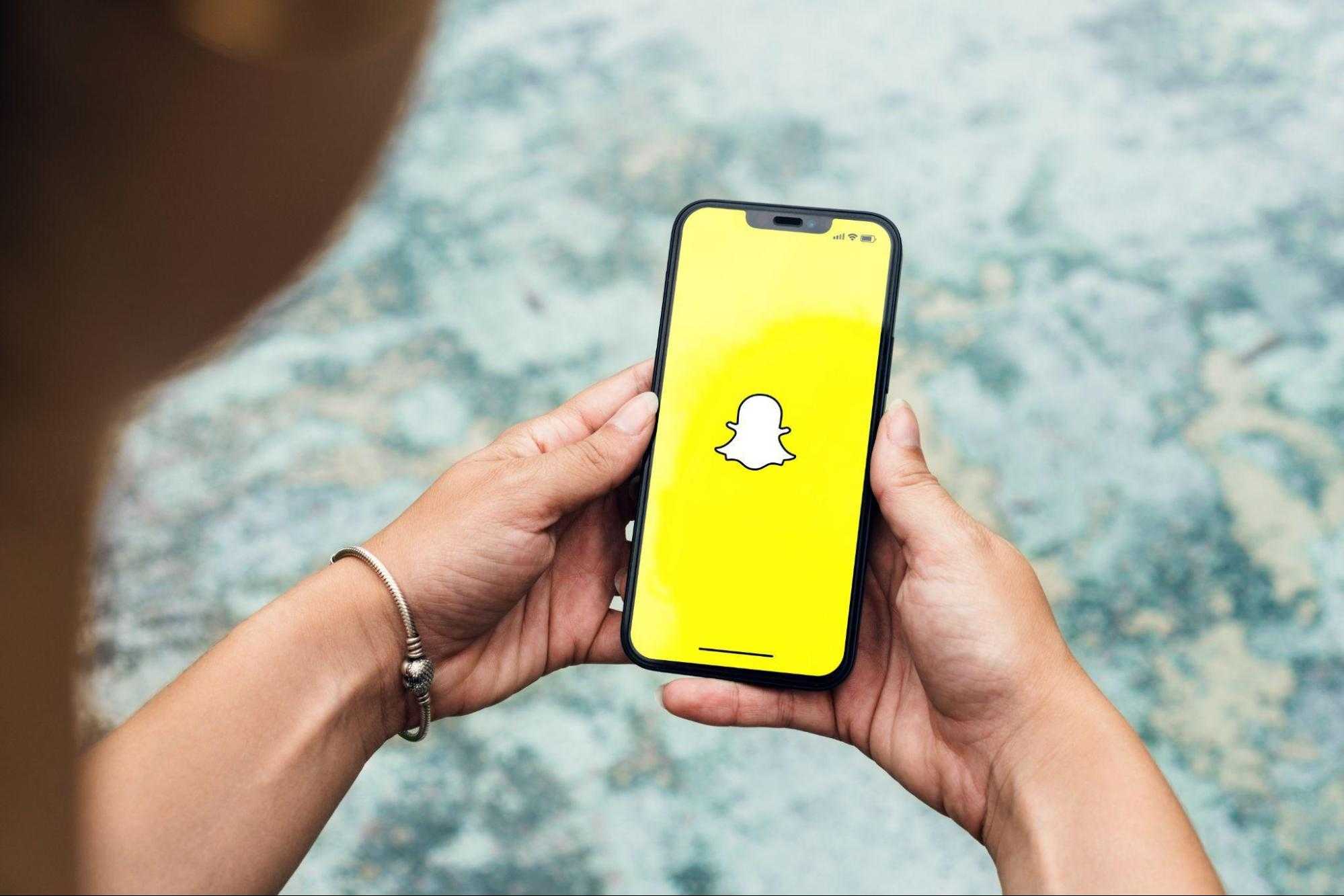 girl holding smartphone with snapchat open